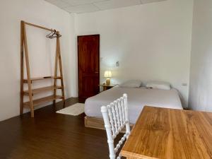 1 dormitorio con cama y mesa de madera en La Casa De Eros, en Ayampe