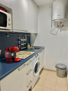 kuchnia ze zlewem i pralką w obiekcie Apartamento nuevo con piscina, temporada w mieście El Puerto de Santa María