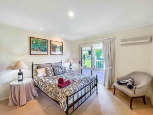 a bedroom with a bed and a chair and a window at Midnight's Promise - Promise 1 in Lovedale