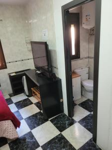 Un baño con inodoro y un televisor sobre un mostrador. en Lunarota Home, en Madrid 4 fotos más