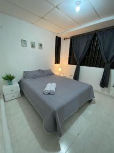 a bedroom with a bed with two white towels on it at Habitaciones independientes cerca al aeropuerto 3 in Cartagena de Indias