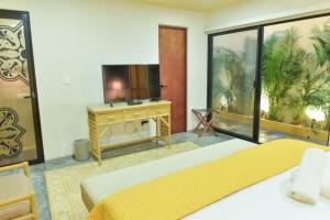 a hotel room with two beds and a television at K an nah Diseño tropical inspirado en el jaguar in Mérida