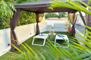 um gazebo com duas cadeiras e uma mesa em K an nah Diseño tropical inspirado en el jaguar em Mérida