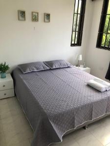 1 dormitorio con 1 cama grande y edredón morado en Habitaciones independientes cerca al aeropuerto 3, en Cartagena de Indias