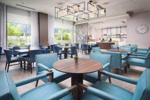 a restaurant with blue chairs and tables and a clock at SpringHill Suites by Marriott Atlanta Downtown in Atlanta