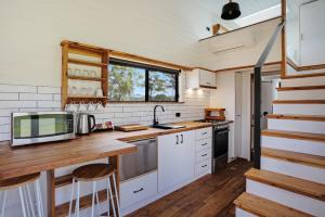 a kitchen with white cabinets and a wooden counter top at Boydtown Beach Holiday Park in Eden