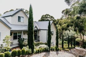 a white house with trees in front of it at Ascona - Hepburn Springs Daylesford in Hepburn Springs