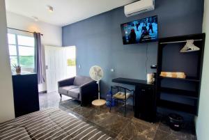 1 dormitorio con sofá y TV en la pared en Cozumel 400A - Vacation Rental, en Cozumel