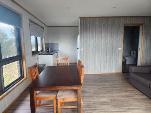 eine Küche und ein Esszimmer mit einem Tisch und Stühlen in der Unterkunft Mount Rumney Escapes - 5 Seaview Kangaroo House in Mount Rumney