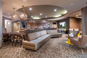 a living room with a couch and a table and chairs at SpringHill Suites by Marriott Colorado Springs South in Colorado Springs