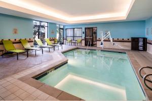 una piscina nella hall dell'hotel con sedie e tavoli di SpringHill Suites by Marriott Colorado Springs South a Colorado Springs