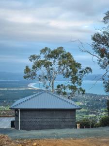 Mount Rumney Escapes - 5 Seaview Kangaroo House في Mount Rumney: مبنى من الطوب على قمة تل