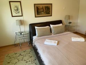 ein Schlafzimmer mit einem großen Bett mit zwei Tischen in der Unterkunft Villa Elita - Bela Crkva in Bela Crkva