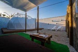 un patio con una mesa y una tienda de campaña en ADAMA Glamping, en Chiclana de la Frontera