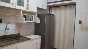 Pé na areia Gonzaguinha São Vicente في ساو فيسينتي: مطبخ صغير مع ثلاجة وميكروويف