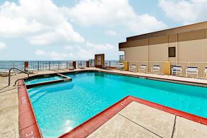 a swimming pool on top of a building with the ocean in the background at Inverness #304 in South Padre Island