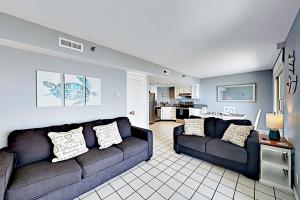 a living room with two couches and a kitchen at Inverness #304 in South Padre Island
