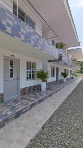 a building with potted plants in front of it at Ecohotel Linda Judith in Bahía Solano