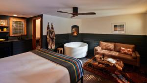 Highlands Resort - Adults Only في جيرنفيل: غرفة نوم بسرير وحوض استحمام وأريكة