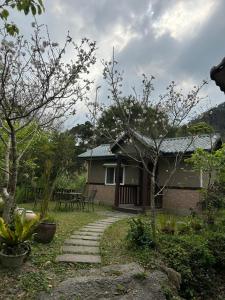 a house with a pathway in front of it at 蓬萊生態農場仙山民宿 in Nanzhuang