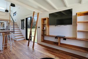 a living room with a tv on the wall of a tiny house at Boydtown Beach Holiday Park in Eden