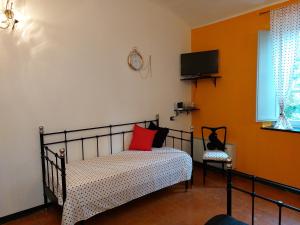 a bedroom with a bed and a tv on the wall at Nonna Litta in Albenga
