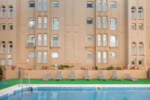 un hôtel avec une piscine en face d'un bâtiment dans l'établissement AC Hotel La Línea by Marriott, à La Línea de la Concepción