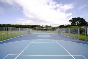 un campo da tennis con canestro da basket di Anglesea Family Caravan Park a Anglesea