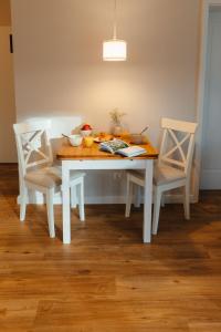 a dining room table with two chairs and a white table at Fine Stuuv in Ratzeburg