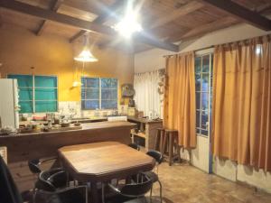 a kitchen with a wooden table and a dining room at Casa alma verde alegria in Luyaba
