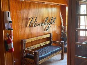 ławka w pokoju z napisem na ścianie w obiekcie Hotel Hambyll,,,,,,,,,,,,,,,,,,,, w mieście Diego de Almagro