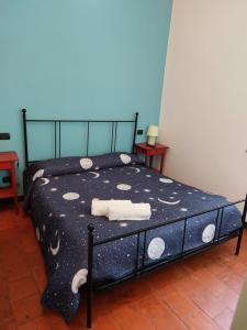a bed with a black and white comforter with towels on it at Nonna Litta in Albenga