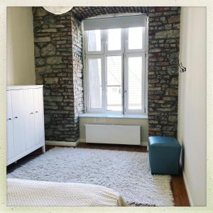 a bedroom with a brick wall and a window at Wohnen im Baudenkmal mitten in der Altstadt in Arnsberg
