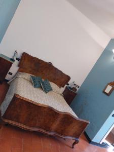 1 dormitorio con cama de madera y 2 almohadas en Nonna Litta, en Albenga