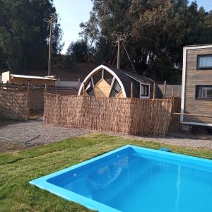 een zwembad in een tuin met een hek bij Tinny cabañas estación ritoque in Quintero