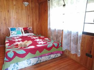1 dormitorio con 1 cama en una habitación con ventana en Résidence Tamaumia - chambre en Hakamui