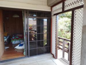 un porche cubierto con puertas correderas de cristal en Résidence Tamaumia - chambre en Hakamui