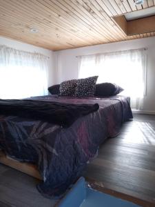 1 dormitorio con 1 cama en una habitación con ventanas en Tinny cabañas estación ritoque en Quintero