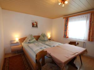 um quarto com uma cama com uma mesa e uma janela em Glantaler em Liebenfels