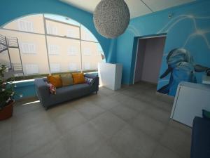 sala de estar con sofá y pared azul en Hostal Giramundo, en Ibiza