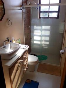 uma casa de banho com um lavatório, um chuveiro e um WC. em Apartamento 5 min do Consulado Americano Porto Alegre em Porto Alegre