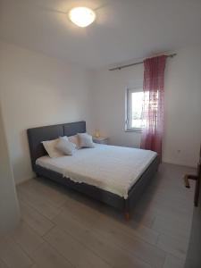 um quarto com uma cama grande e uma janela em Apartment Povljana 224b em Povljana