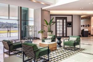 Marriott Panama Hotel - Albrook في مدينة باناما: لوبي وكراسي خضراء وغرفة انتظار