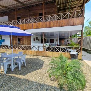 un patio con mesas y sombrillas frente a un edificio en Ecohotel Linda Judith, en Bahía Solano