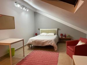 una camera con letto e sedia rossa di À Descoberta d'Angra! ad Angra do Heroísmo