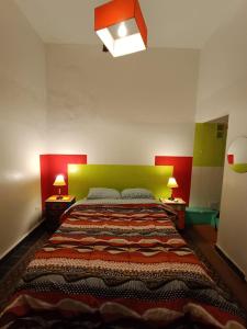 a bedroom with a large bed with a green headboard at Hostel Morada Roots in Cordoba