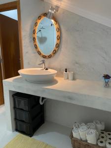 ein Badezimmer mit einem Waschbecken und einem Spiegel auf der Theke in der Unterkunft À Descoberta d'Angra! in Angra do Heroísmo