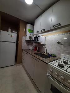 cocina con electrodomésticos blancos y nevera blanca en Lavalle 899 en San Miguel de Tucumán
