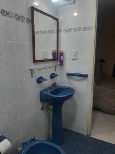 y baño con lavabo azul y espejo. en Lavalle 899 en San Miguel de Tucumán