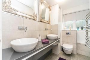 a white bathroom with a sink and a toilet at 10 Boutique Studio Apartment near Tube - quiet location in Little Missenden